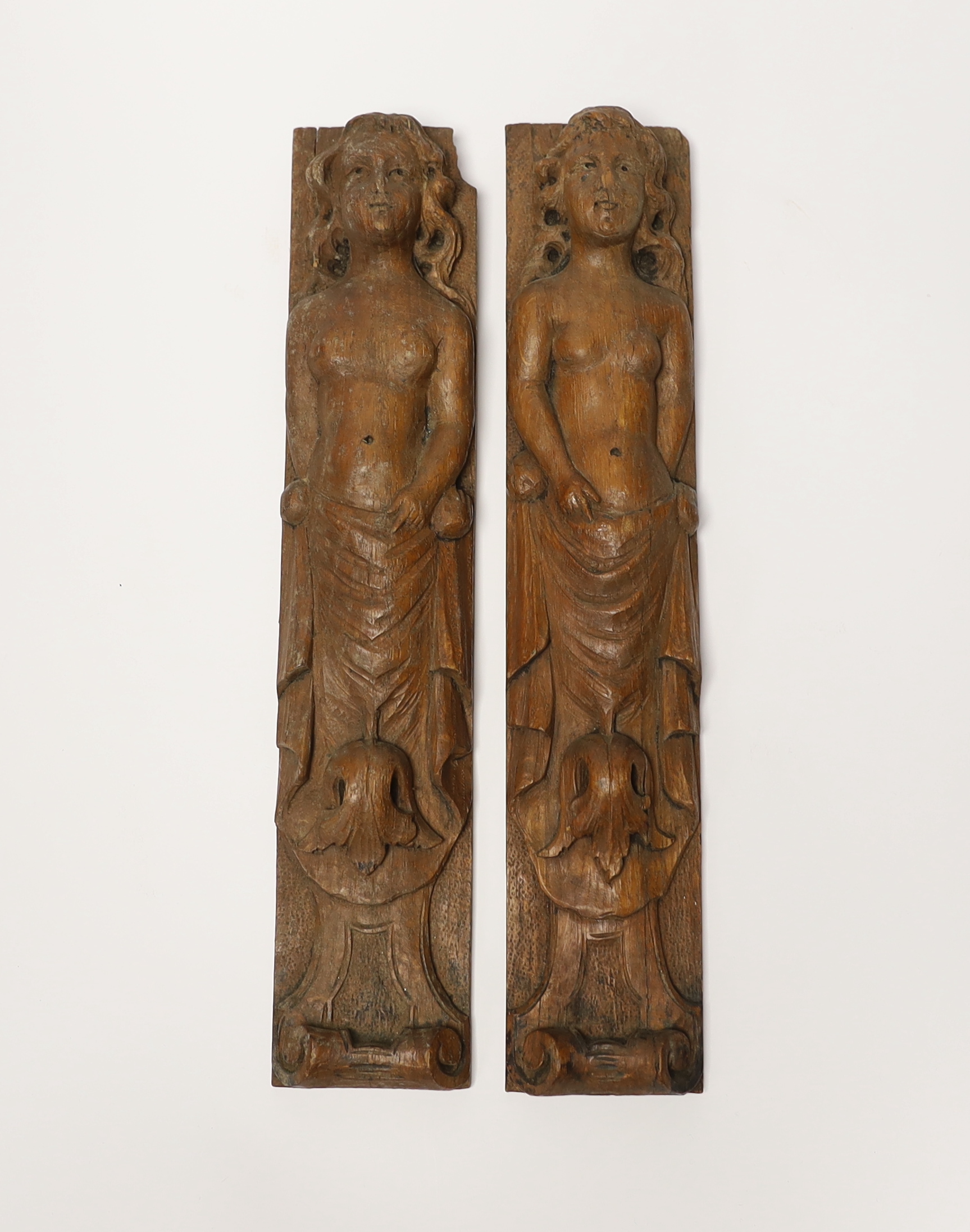 A pair of 17th century carved wood terminal figures, 39cm high